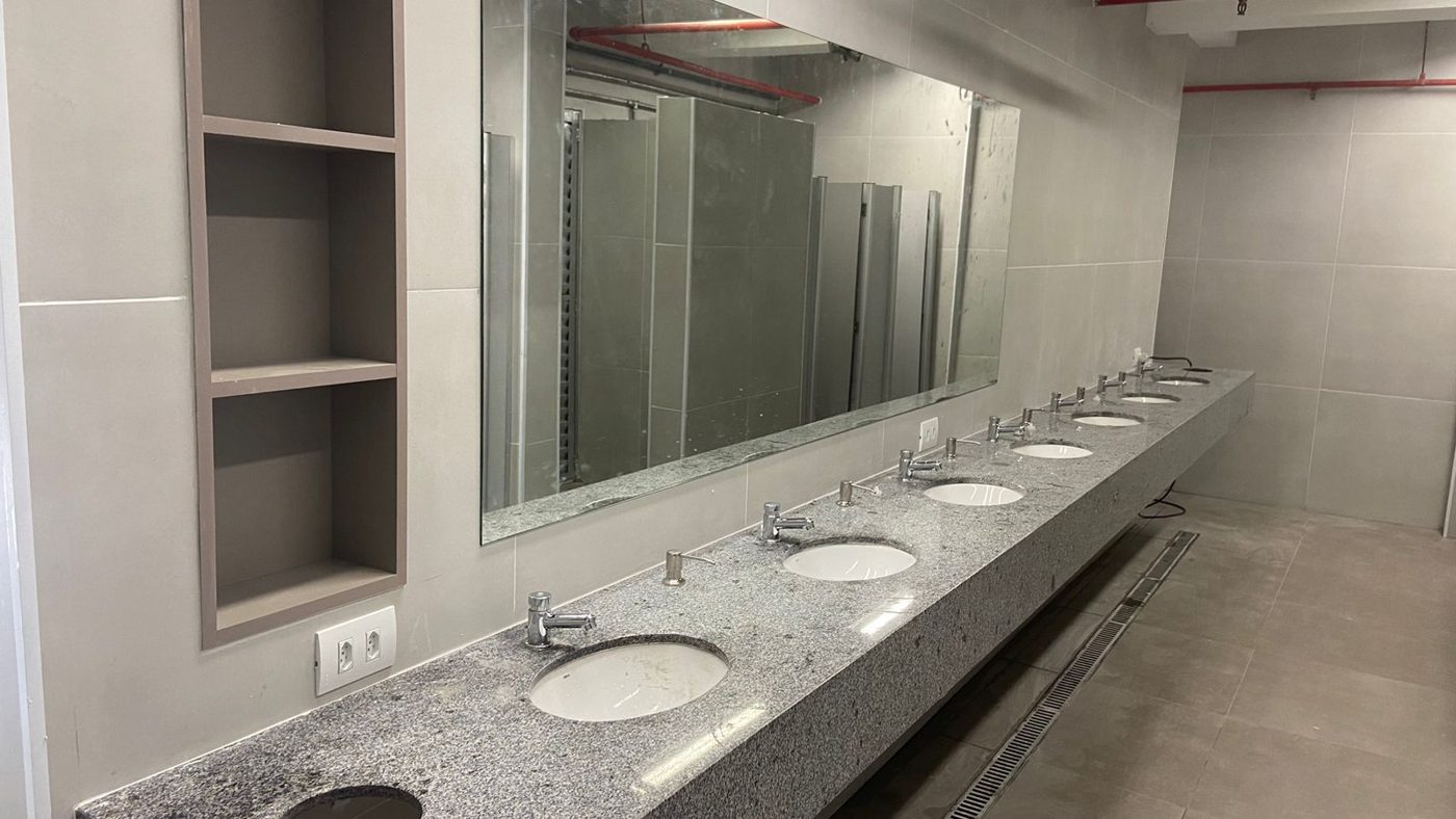 Banheiro reformado com bancada de granito e louças instaladas